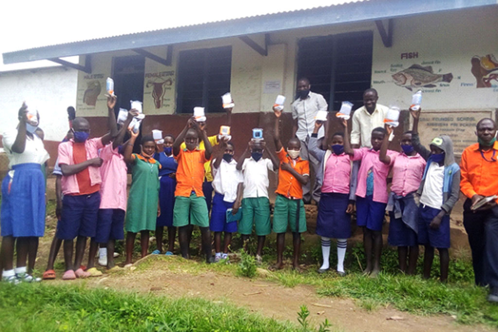 Pupils of Kasingiri Primary School receive solar lamps to help them revise their books at night